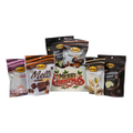 Bedre light-green retro Merry Christmas gift box with Pecan Sensations, Peppermint Bark, and Corn Twists pouches nestled behind it, and a black pouch partially visible behind them