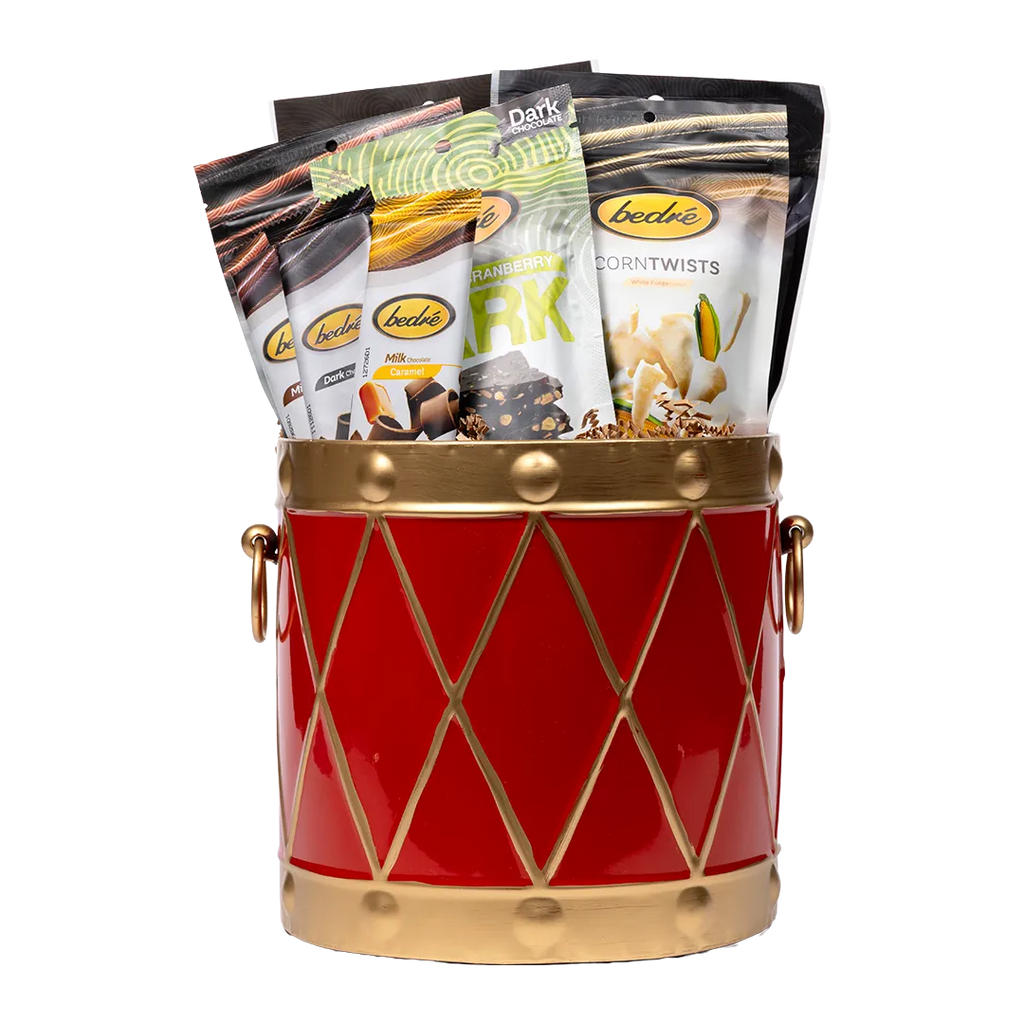 Bedré Fine Chocolate red and gold Christmas Drum tin (large), filled with Corn Twists, chocolate bars, and Pistachio Cranberry Bark pouches