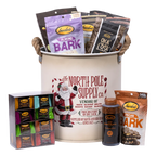 Bedré Fine Chocolate North Pole Supply Co. canister styled with a boxed Melts assortment, Dark Chocolate Premium Sauce, and Pecan Bark displayed alongside