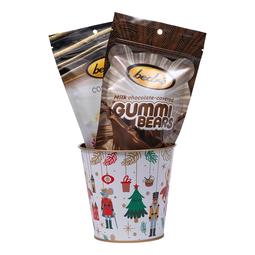 Bedré Fine Chocolate Nutcracker Suite tin (small) illustrated with a ballerina and nutcracker prince, filled with Almond Bark and Melts Caramel pouches